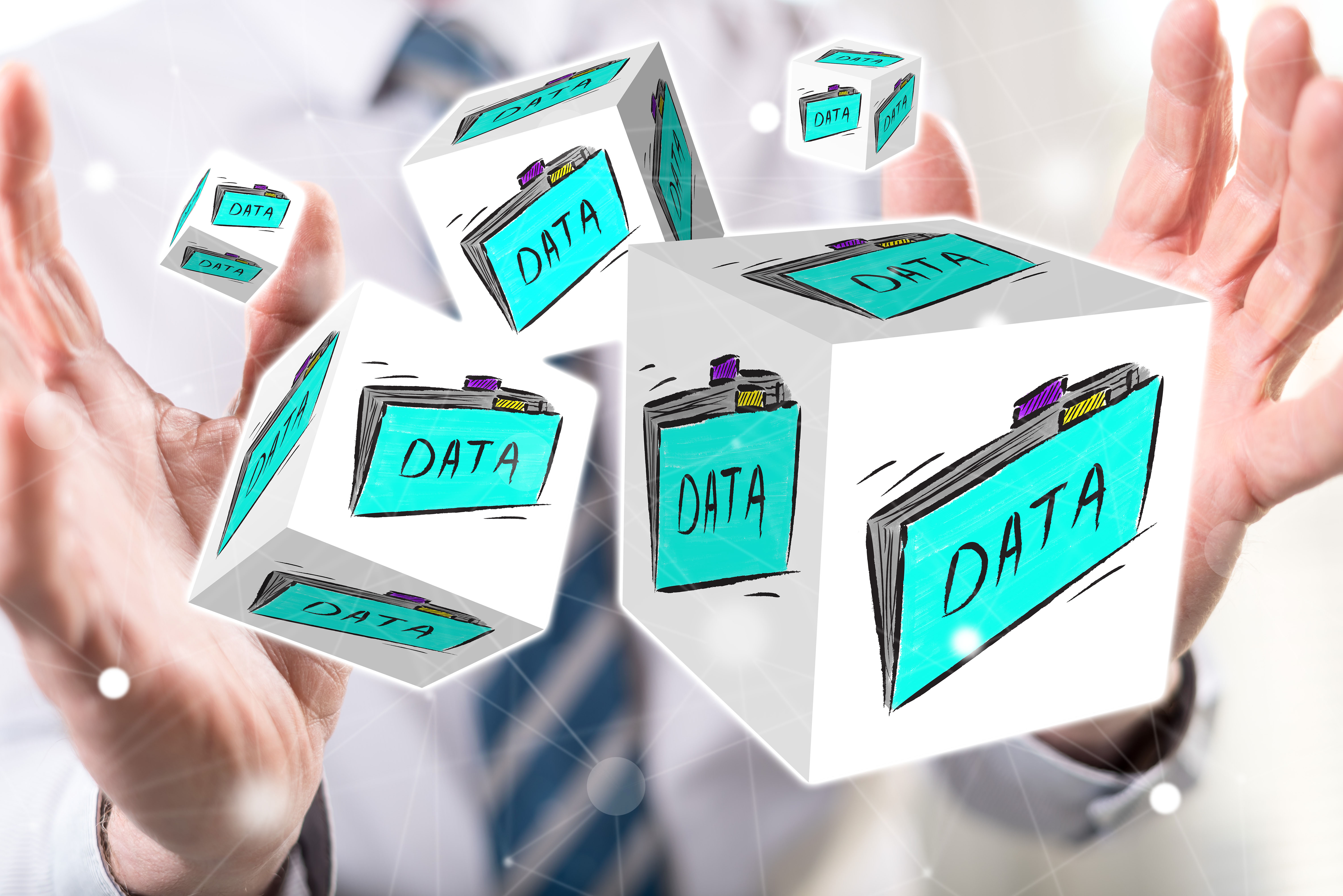 A person holding floating 3D cubes labeled 'DATA' to represent data management.