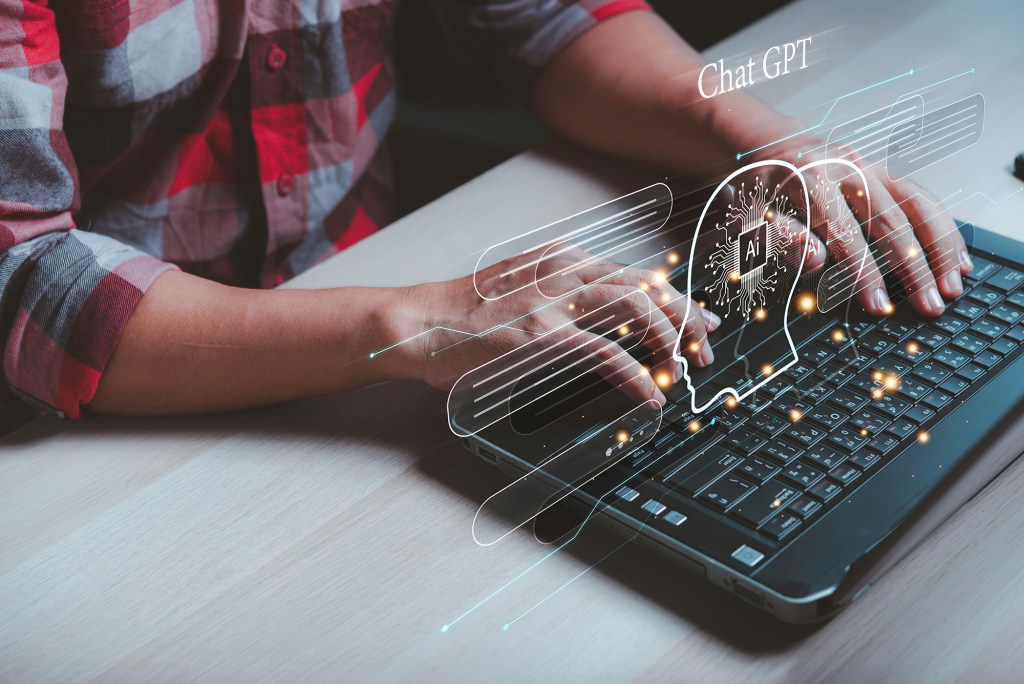 A person typing on a laptop with an overlay of AI and ChatGPT graphics.